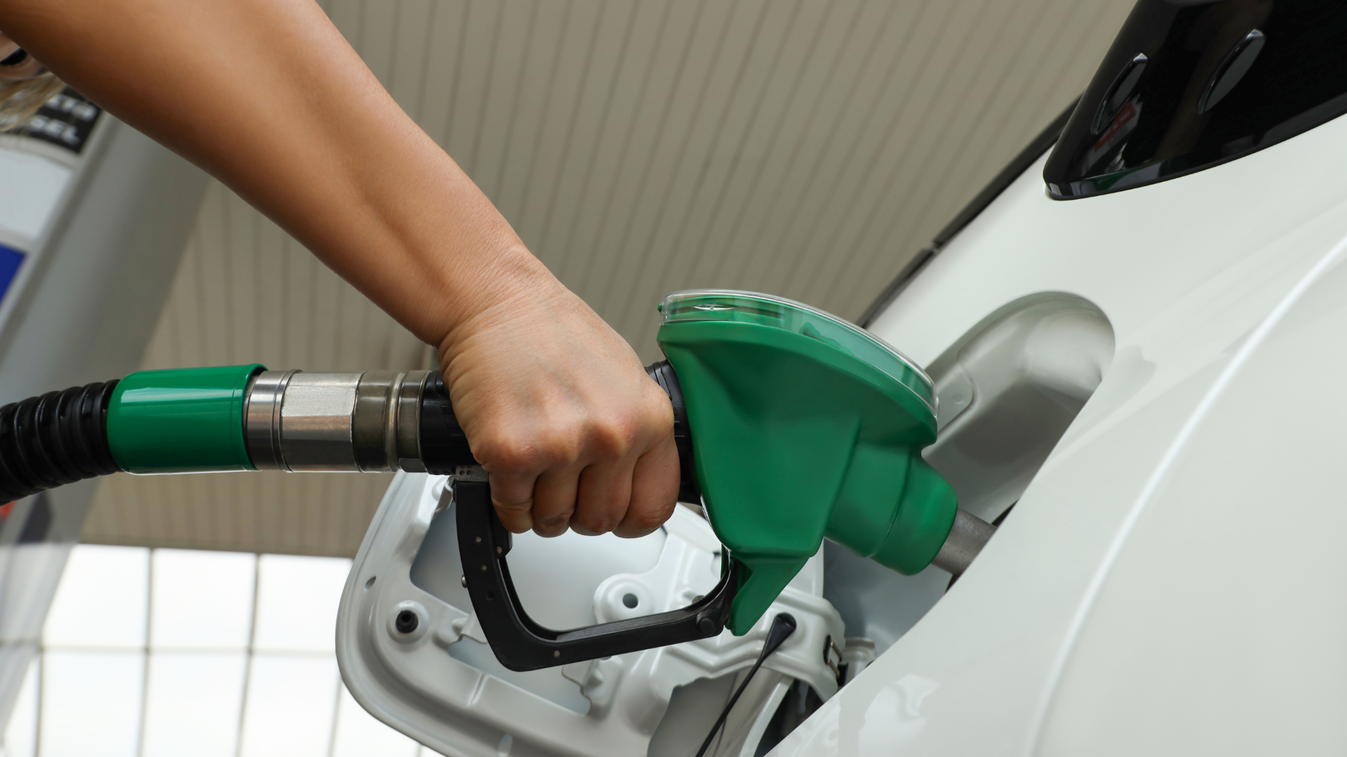 Gasoline pump nozzle fueling a vehicle