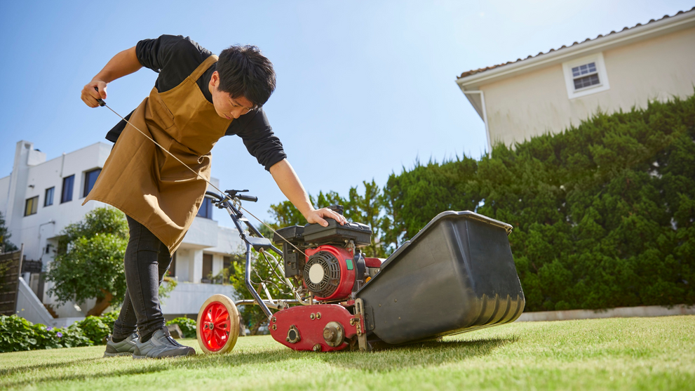 Homeowner attempting to restart mower struggling with old gas symptoms