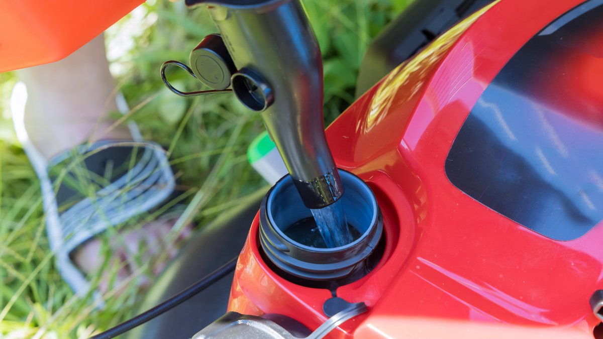 Refueling a lawn mower with fresh gas as part of a spring start routine