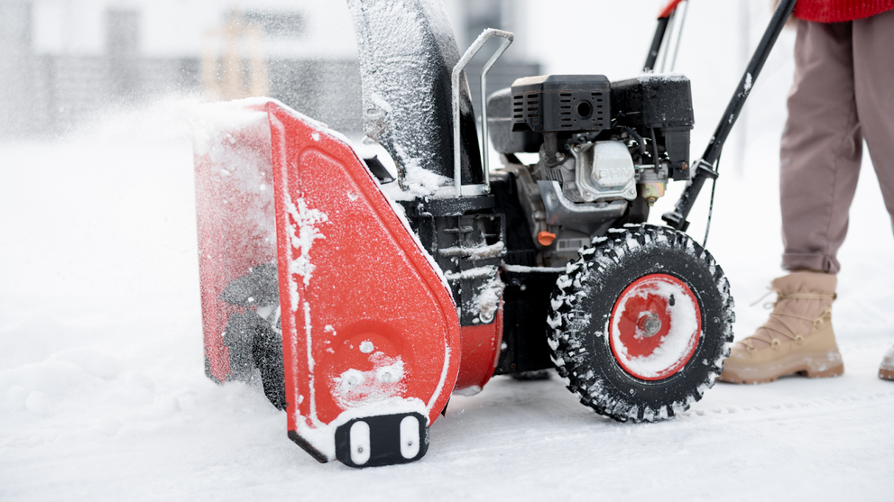 Snow blower clearing snow on driveway