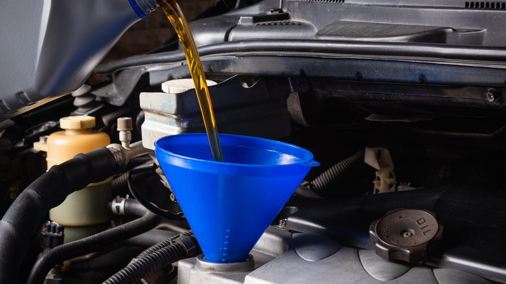 Synthetic oil being poured into engine funnel