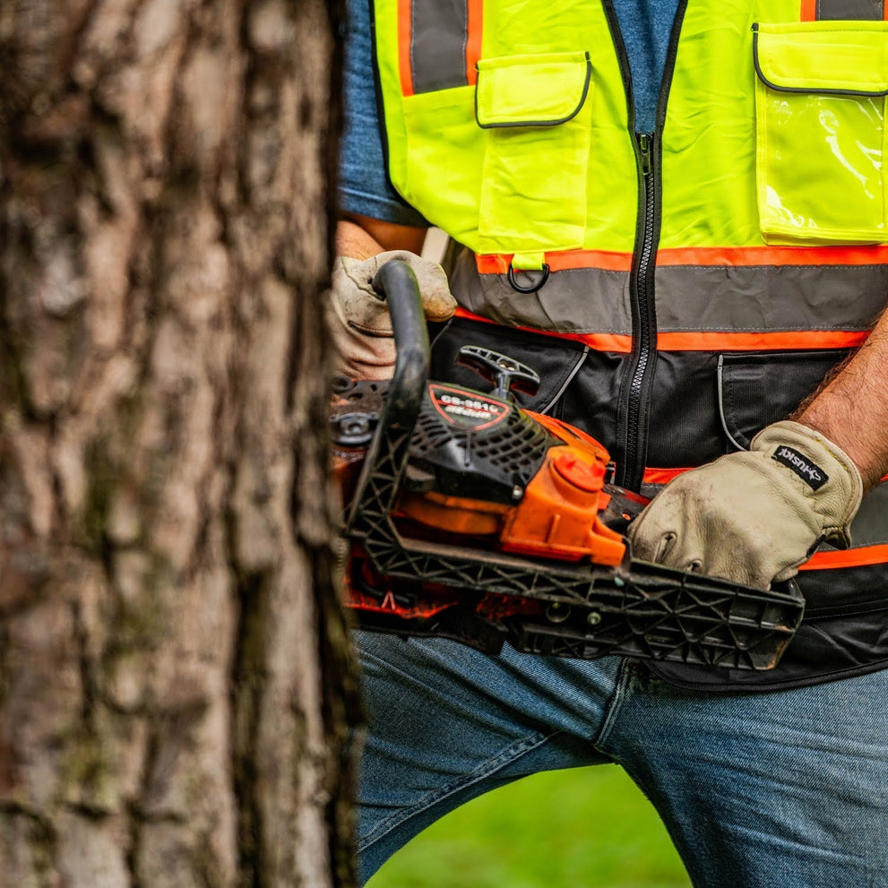 Worker Cutting A Tree With A Gas-Powered Chainsaw