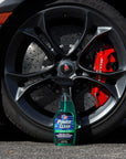 lifestyle image showing a bottle of VP Power Clean all-purpose cleaner for cars sitting on the ground in front of a wheel of a sports car