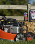 Lifestyle image showing the front of a lawn mower in the foreground and a one-gallon can of VP 4-cycle fuel in the background sitting atop a short bale of hay.