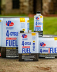 Different container sizes of VP Racing 4-Cycle Fuel for small engines. The containers are arranged outdoors on concrete, ranging from quarts to large pails.