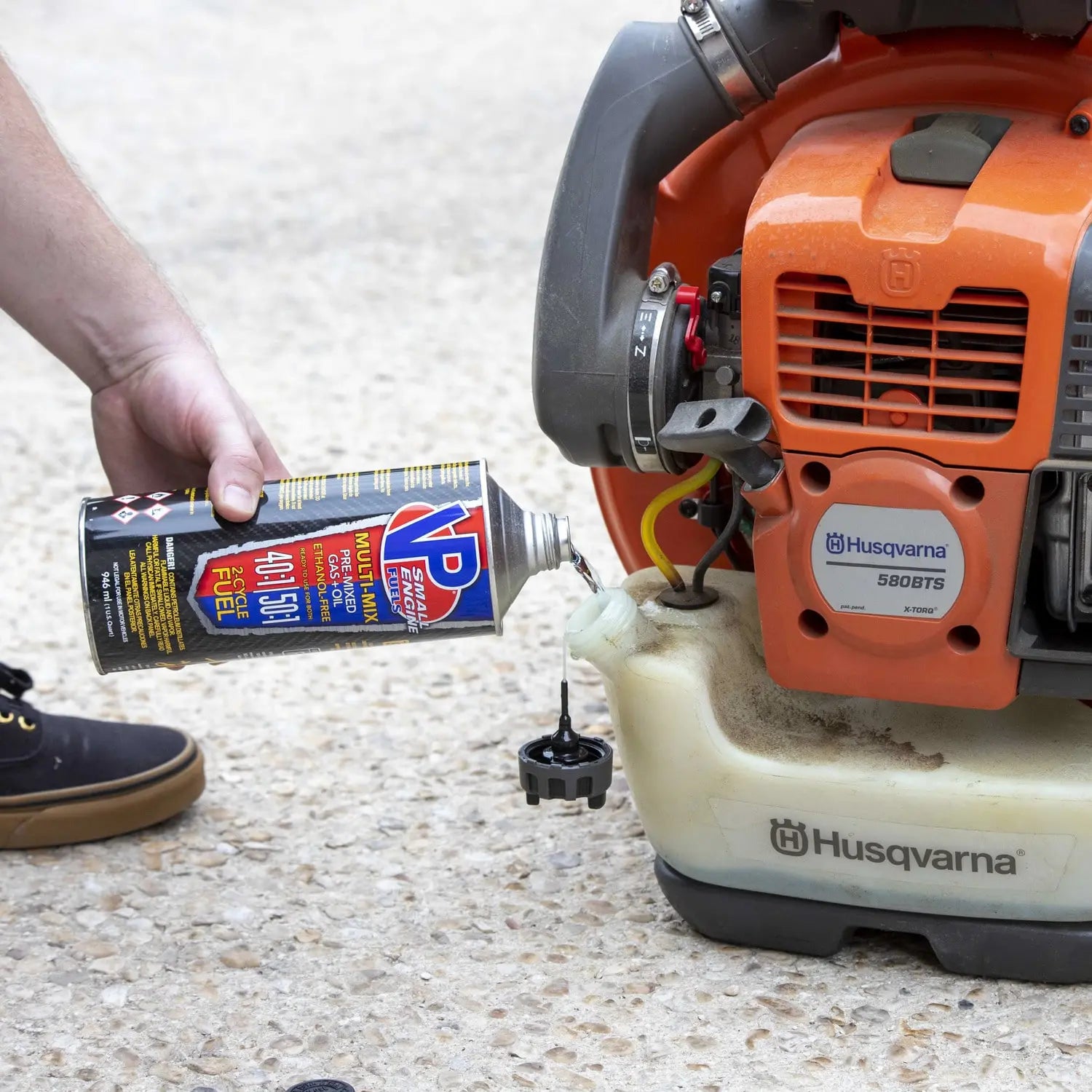 closeup lifestyle image showing someone pouring a quart of VP Multi-Mix 40:1/50:1 Premixed Fuel for 2-Cycle Engines into a leaf blower gas tank