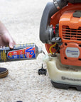 closeup lifestyle image showing someone pouring a quart of VP Multi-Mix 40:1/50:1 Premixed Fuel for 2-Cycle Engines into a leaf blower gas tank