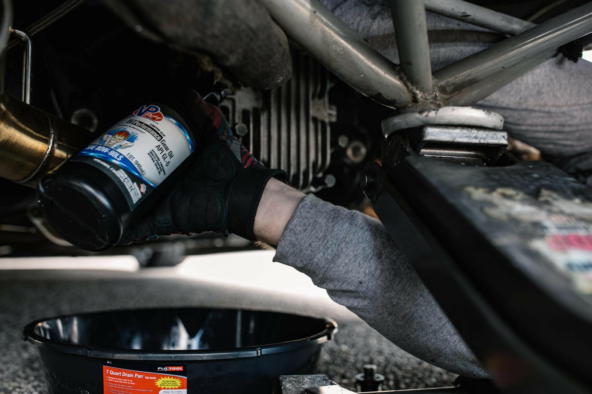 lifestyle image showing a mechanic holding a bottle of VP Hi-Performance 80w90 GL5 gear oil