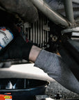 lifestyle image showing a mechanic holding a bottle of VP Hi-Performance 80w90 GL5 gear oil