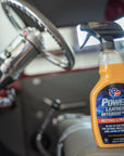 lifestyle image showing a bottle of VP Racing's car detailing leather cleaner sitting on the driver's seat of a car