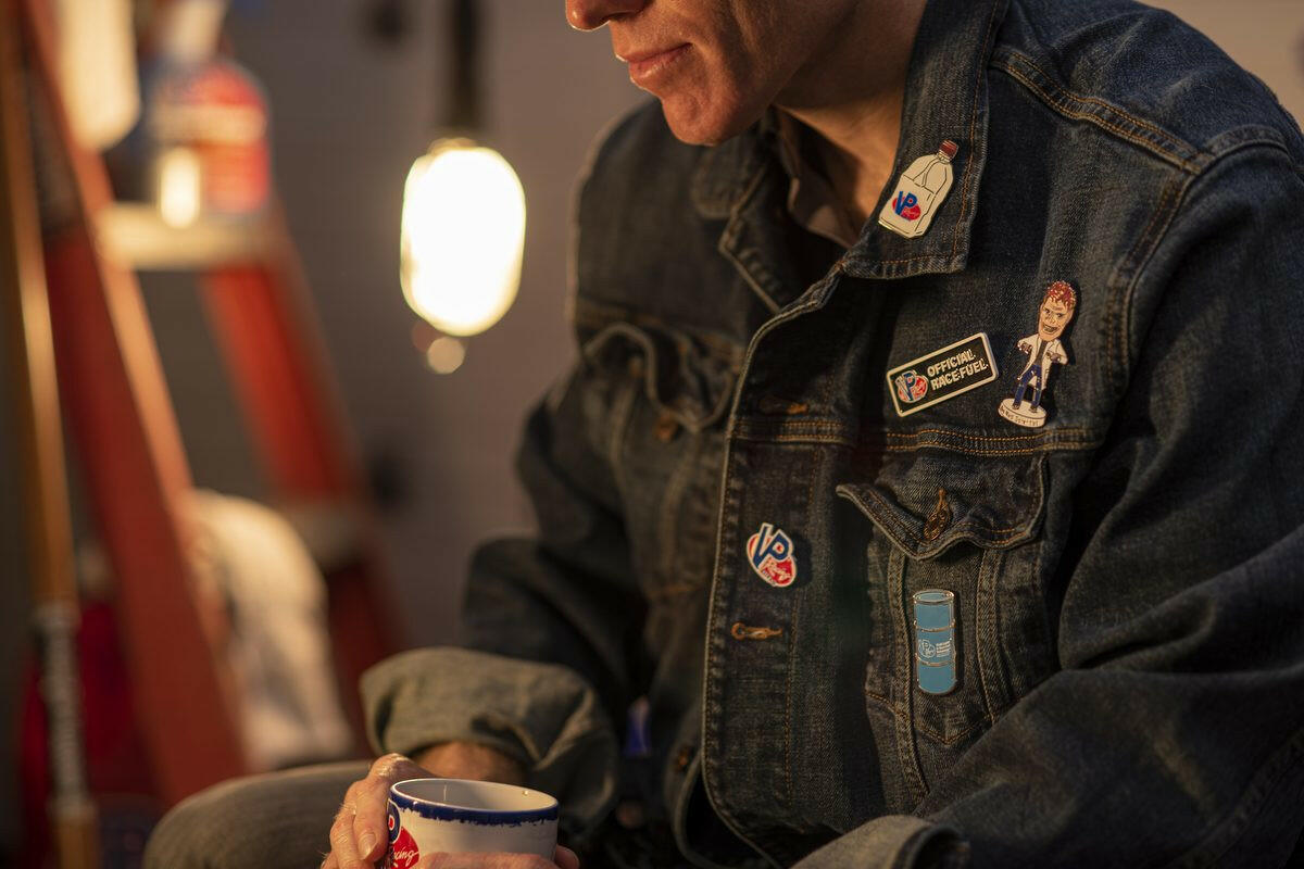 lifestyle image of a male wearing a denim jacket featuring the VP Racing fuel drum enamel pin and other VP pins