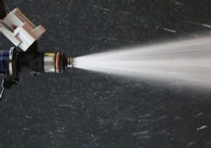 close up of an automobile fuel injector spraying gasoline.