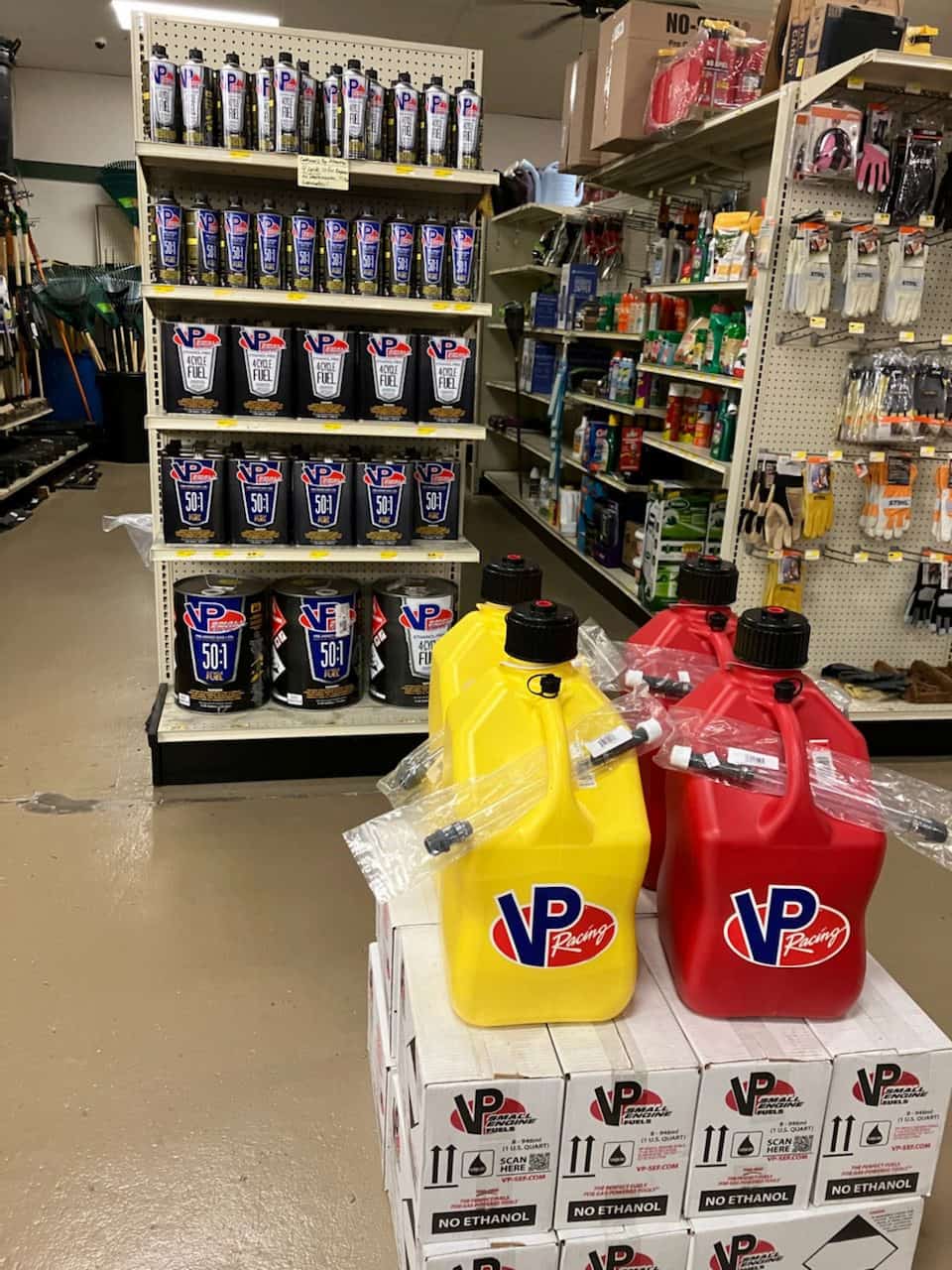 VP Small Engine Fuels on shelves inside D-S Lawn & Auto, with VP Motorsport Containers displayed. in front. Owner David McClinton says VP small engine fuel is the best gas for lawnmowers and other portable outdoor equipment.