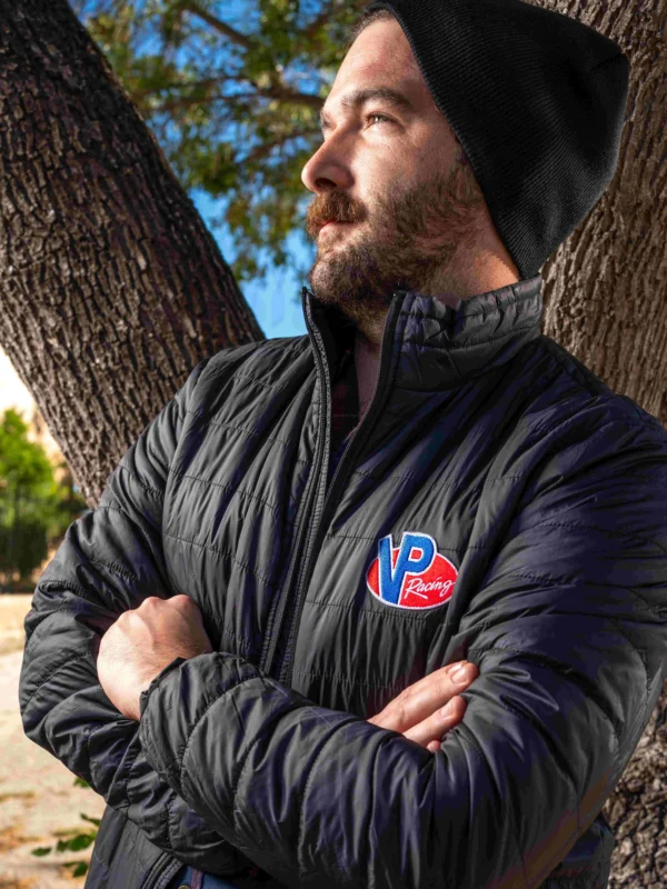 Lifestyle image of male model outside and wearing the VP Turbo Jacket. His arms are crossed and he's looking off to his right