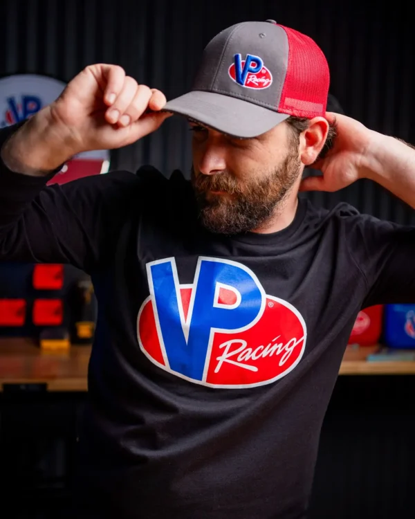 Lifestyle image of male in a VP Racing red and grey trucker hat with VP Racing long sleeve shirt.